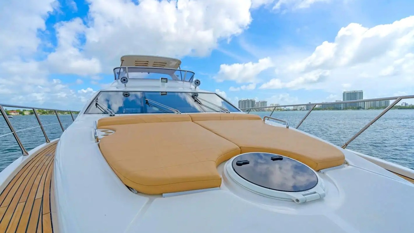 Luxury yacht deck with tan cushions and city skyline in the background.