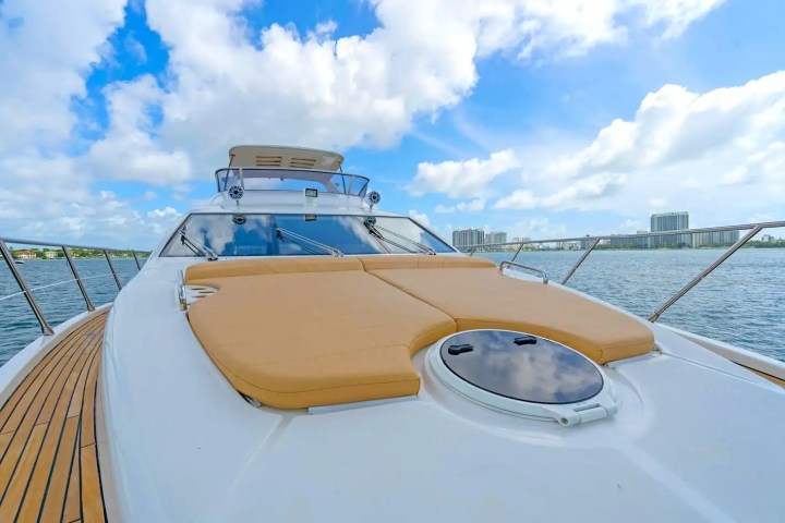 Luxury yacht deck with tan cushions and city skyline in the background.