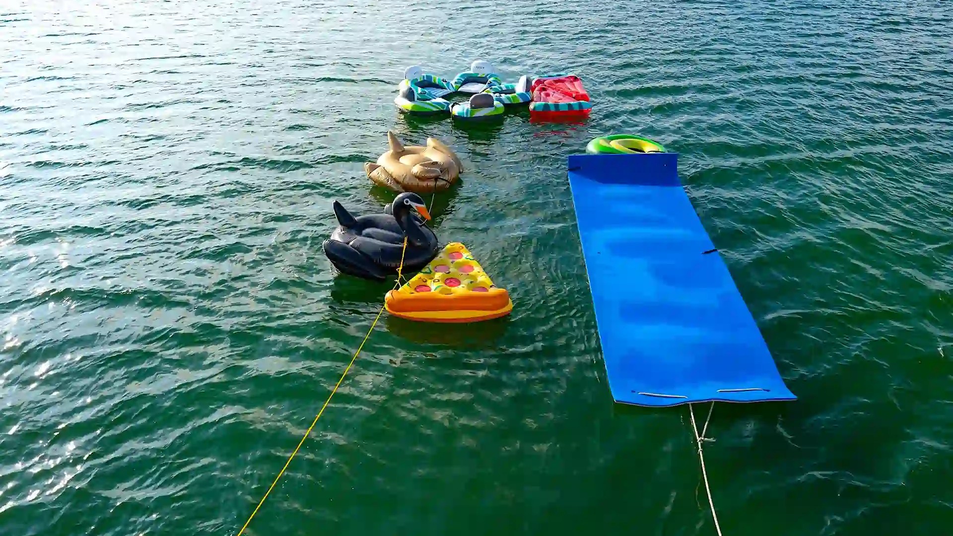 Stern view of 65′ Azimut yacht with floating mat and inflatables