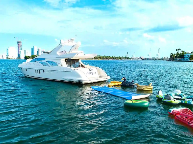 65′ Azimut luxury yacht cruising near Miami Beach skyline with small boats nearby