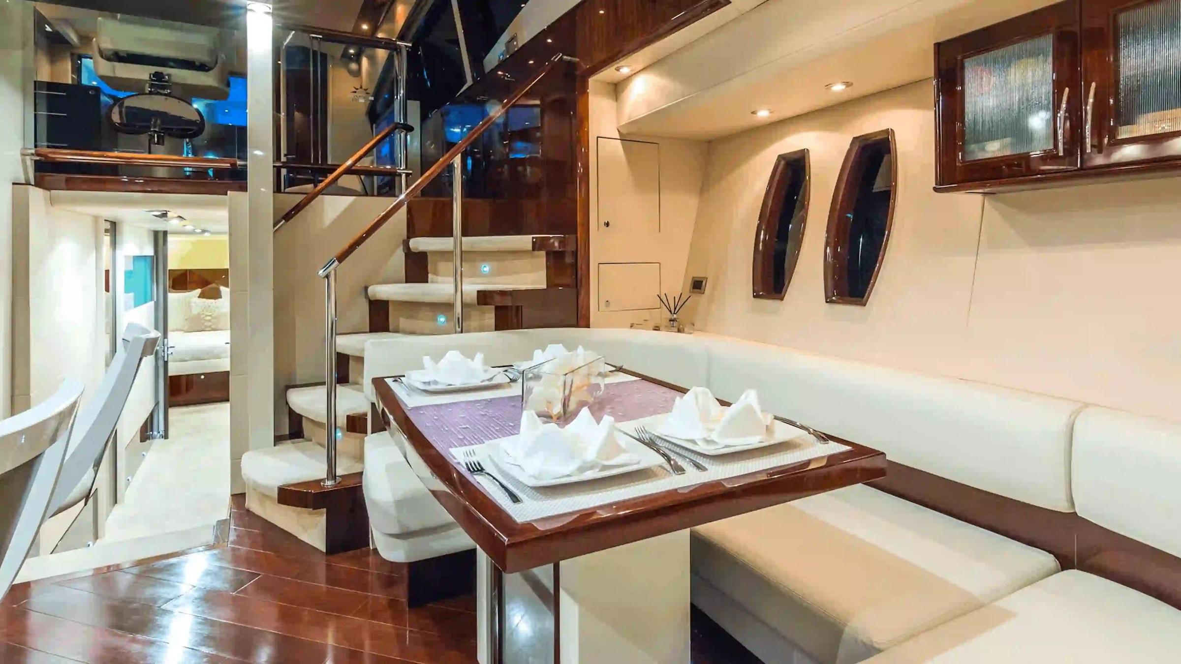 75' Lazzara yacht charter dining salon interior in Miami Beach with luxury seating and staircase