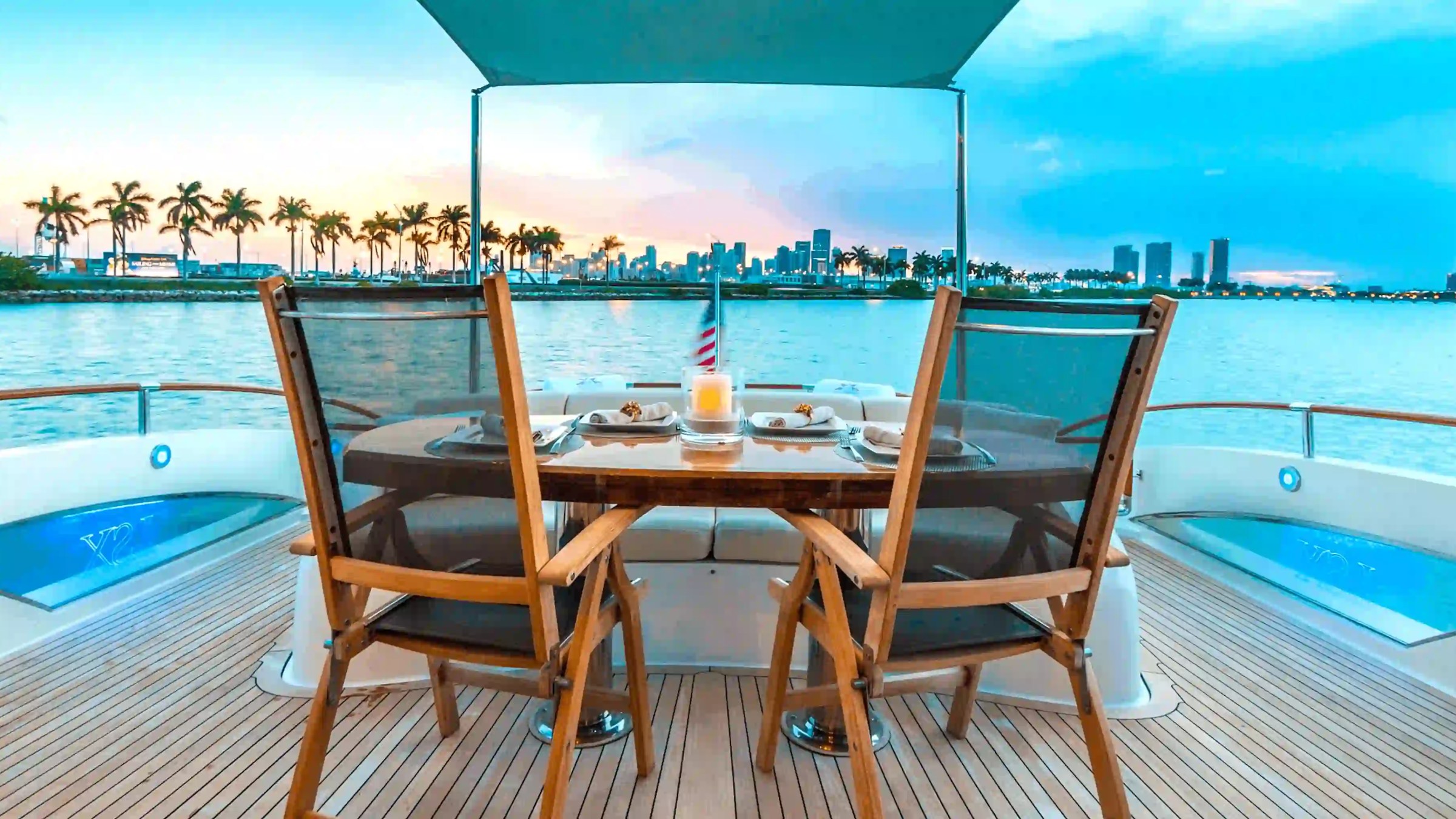 75' Lazzara yacht charter aft deck dining with Miami skyline sunset view Biscayne Bay