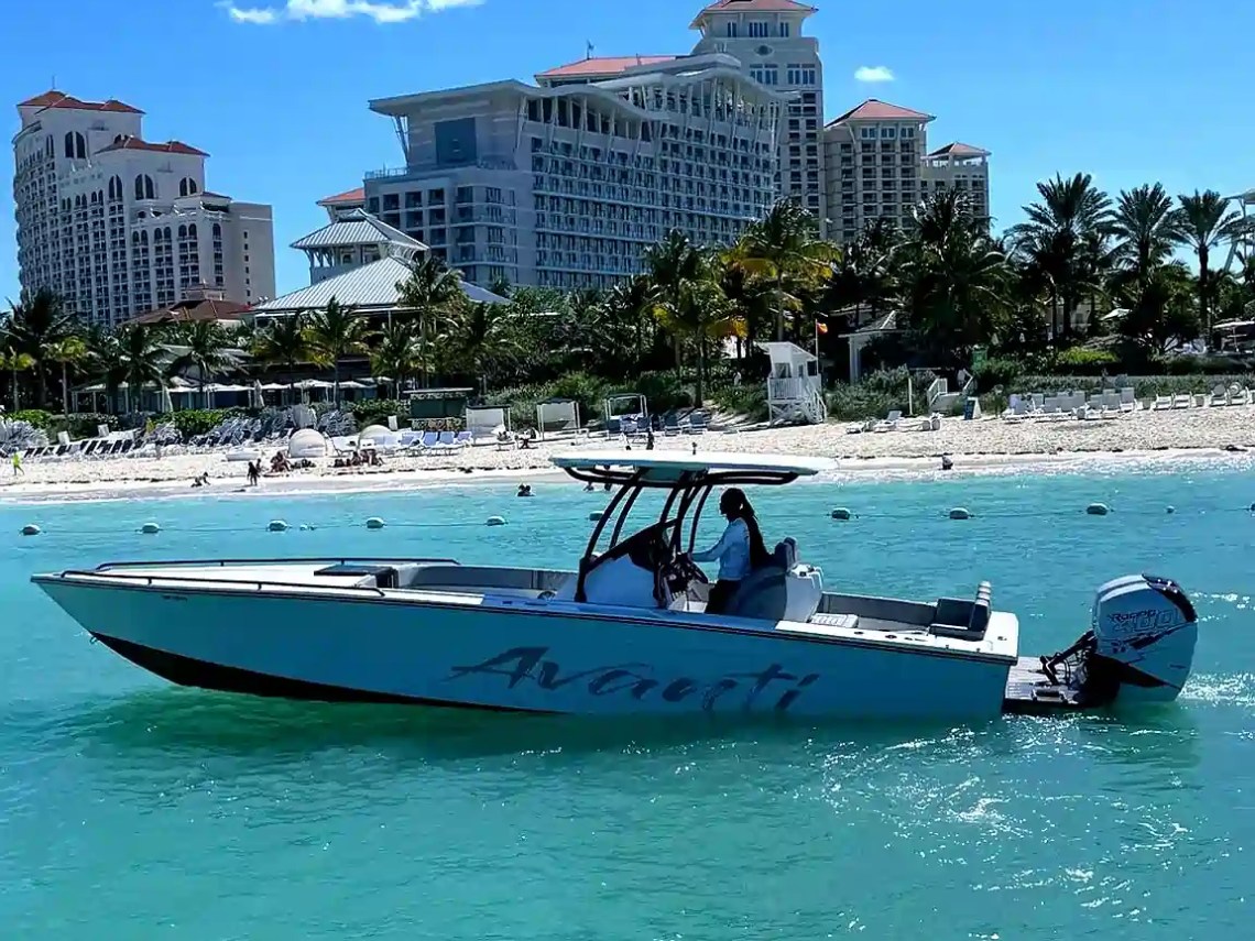 36 Avanti Boat Rental cruising turquoise waters off Nassau Bahamas with resort beachfront backdrop, center console profile, tropical Gulf Coast style boating scene