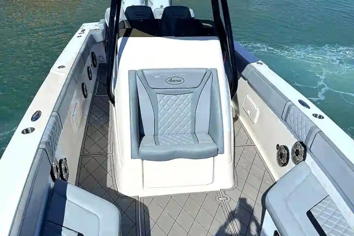 Interior view of a modern speedboat on water with seating and canopy.