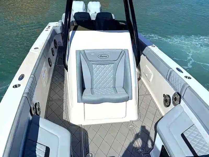 Interior view of a modern speedboat on water with seating and canopy.