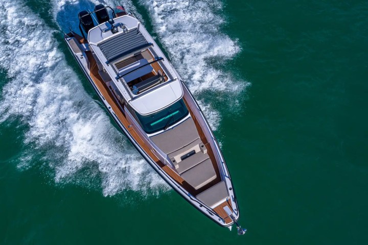 Aerial view of a motor yacht cruising on clear blue water.