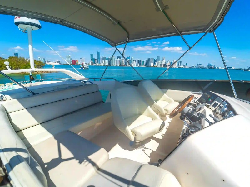 Boat interior with city skyline view over calm blue water.