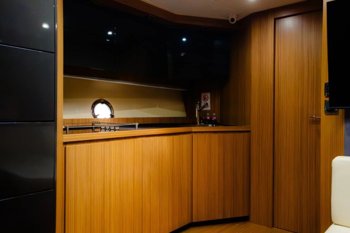 Modern boat interior with wood paneling, small window, and minimalist furnishings.