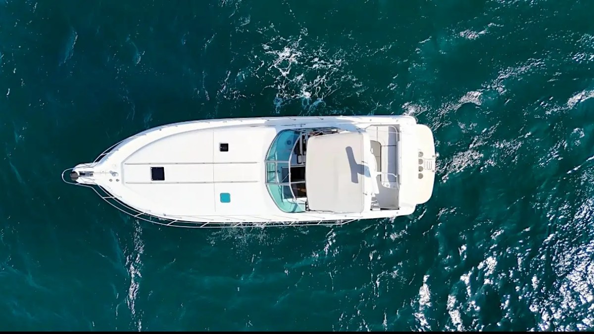 Aerial view of a white yacht sailing on blue ocean waters.