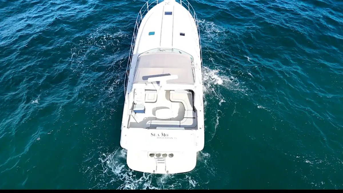 Aerial view of a white boat navigating through blue ocean waters.
