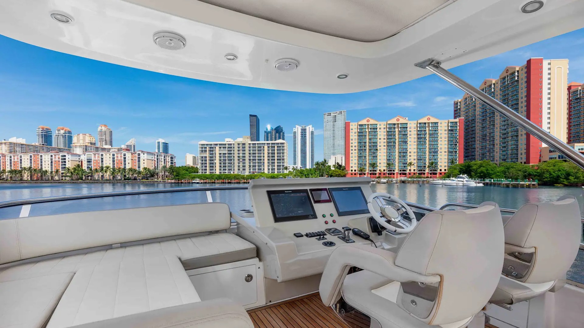 Boat cockpit with city skyline view across calm water.
