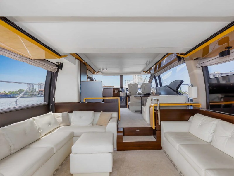 Luxury yacht interior with white sofas and panoramic windows.