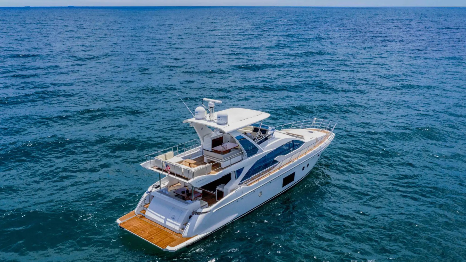 White luxury yacht on calm blue sea, under clear sky.