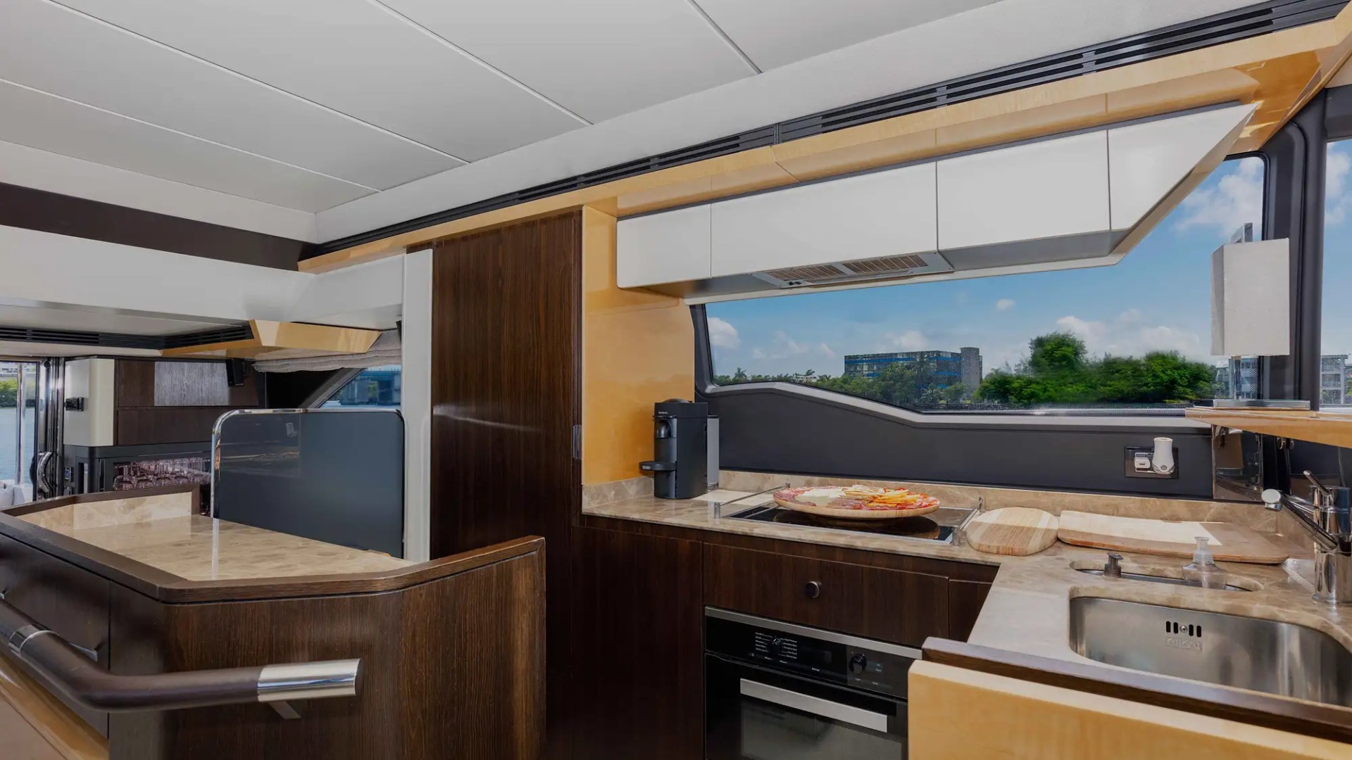Modern yacht kitchen with wood panels, marble countertops, and built-in appliances.