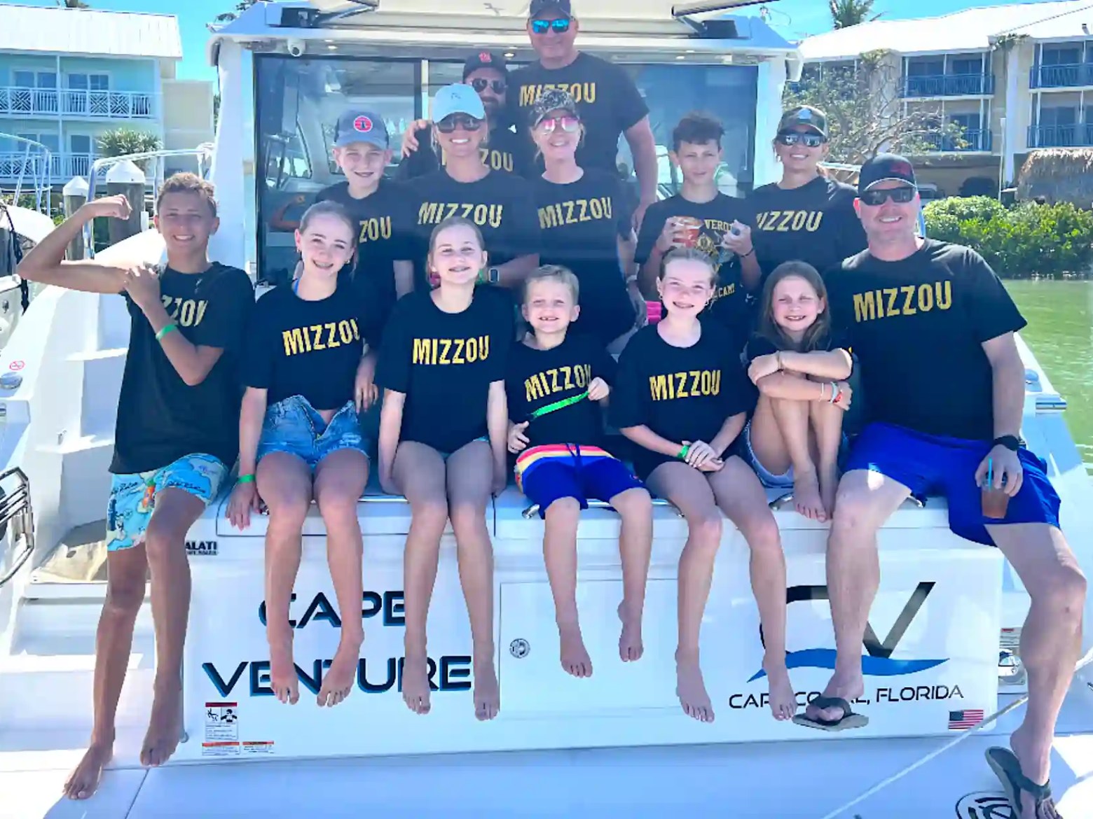 Group of people on a boat wearing matching 'MIZZOU' shirts.