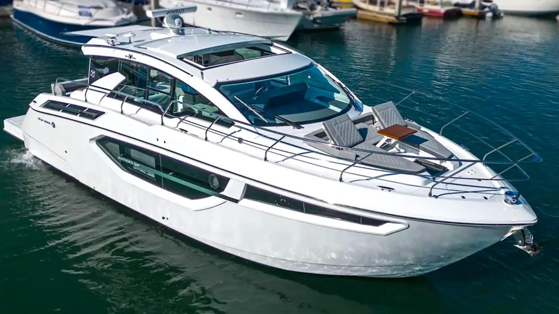 Luxury white yacht docked in a marina with several other boats.