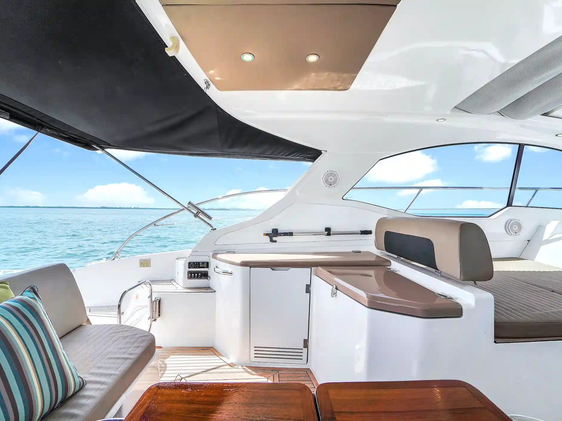 Interior of a luxury yacht with cushioned seating and a sea view.