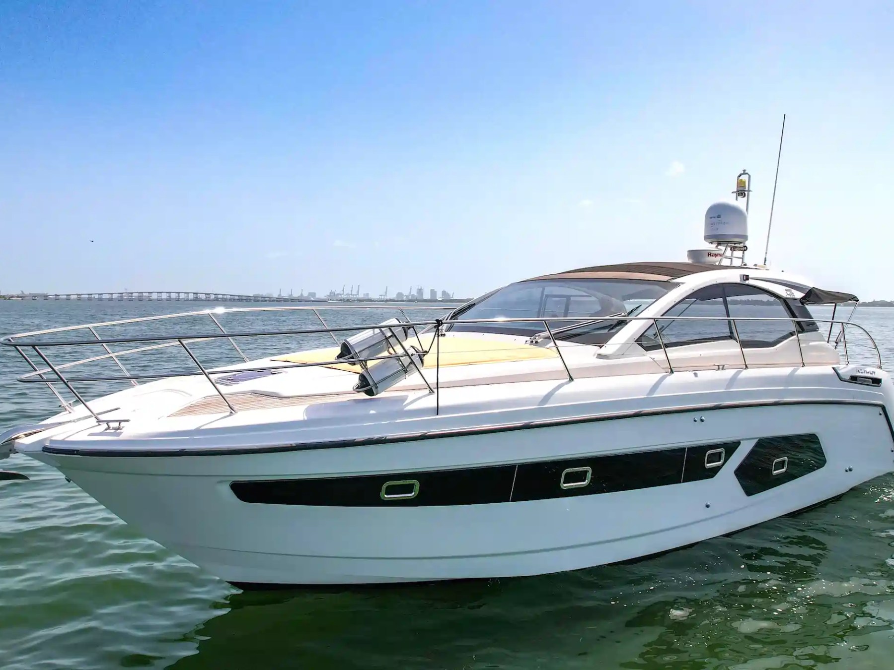 White luxury yacht sailing on calm blue water.