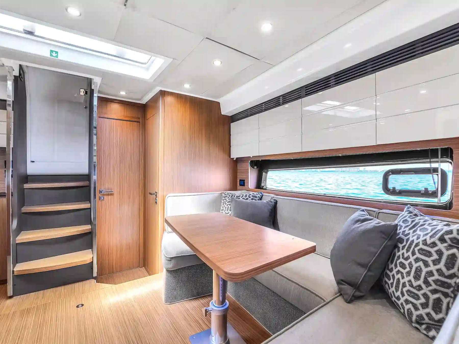 Modern boat interior with wood paneling, seating area, and stairs.