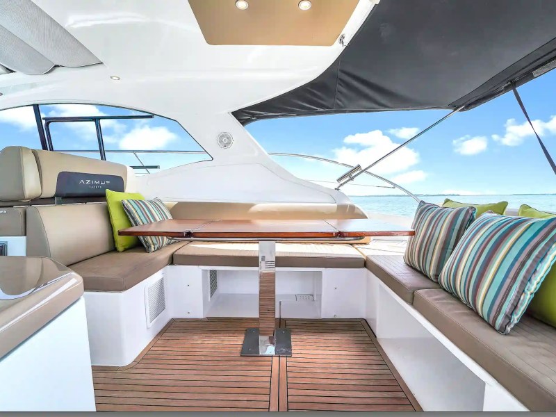 Luxury yacht deck with cushioned seating and striped pillows.