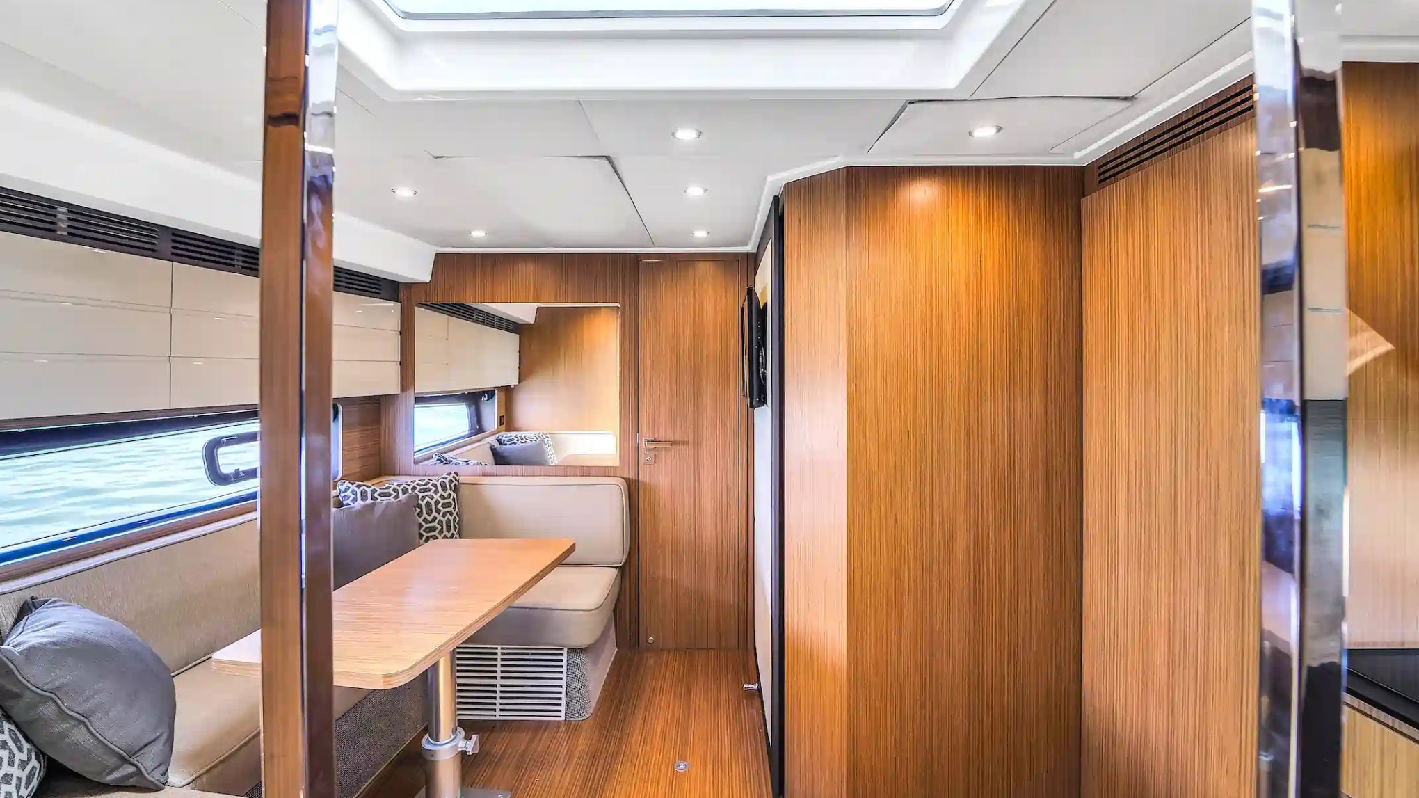 Modern yacht interior with wood paneling and cozy seating.