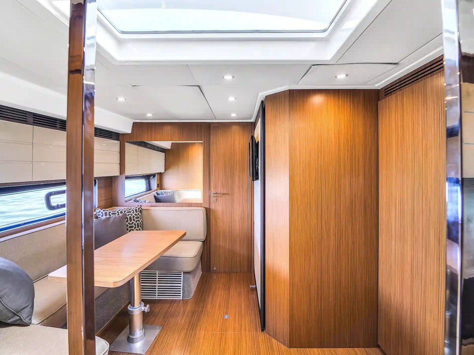 Modern yacht interior with wood paneling and cozy seating.