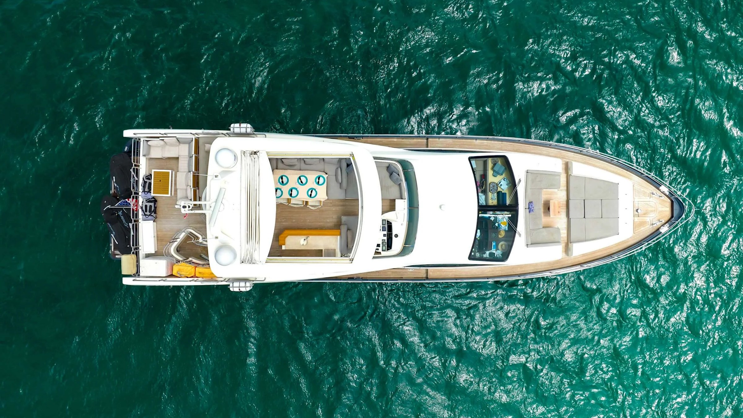 84' Azimut Yacht Charter captured from an overhead perspective in Biscayne Bay, highlighting the bow sunpad, aft dining area, open deck layout, and turquoise Miami waters.