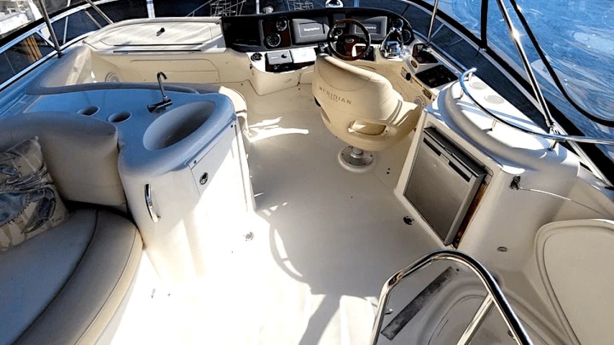 This 44 foot Meridian Boat Rental features a flybridge helm station with captain’s chair, navigation controls, wet bar, and lounge seating while docked in Cape Coral, Florida.