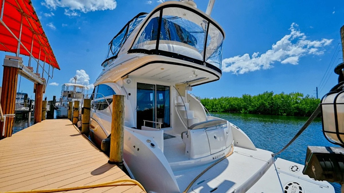 This 44 foot Meridian Boat Rental is docked at a Cape Coral marina with a spacious swim platform, aft seating area, and mangrove-lined Southwest Florida waterways visible nearby.