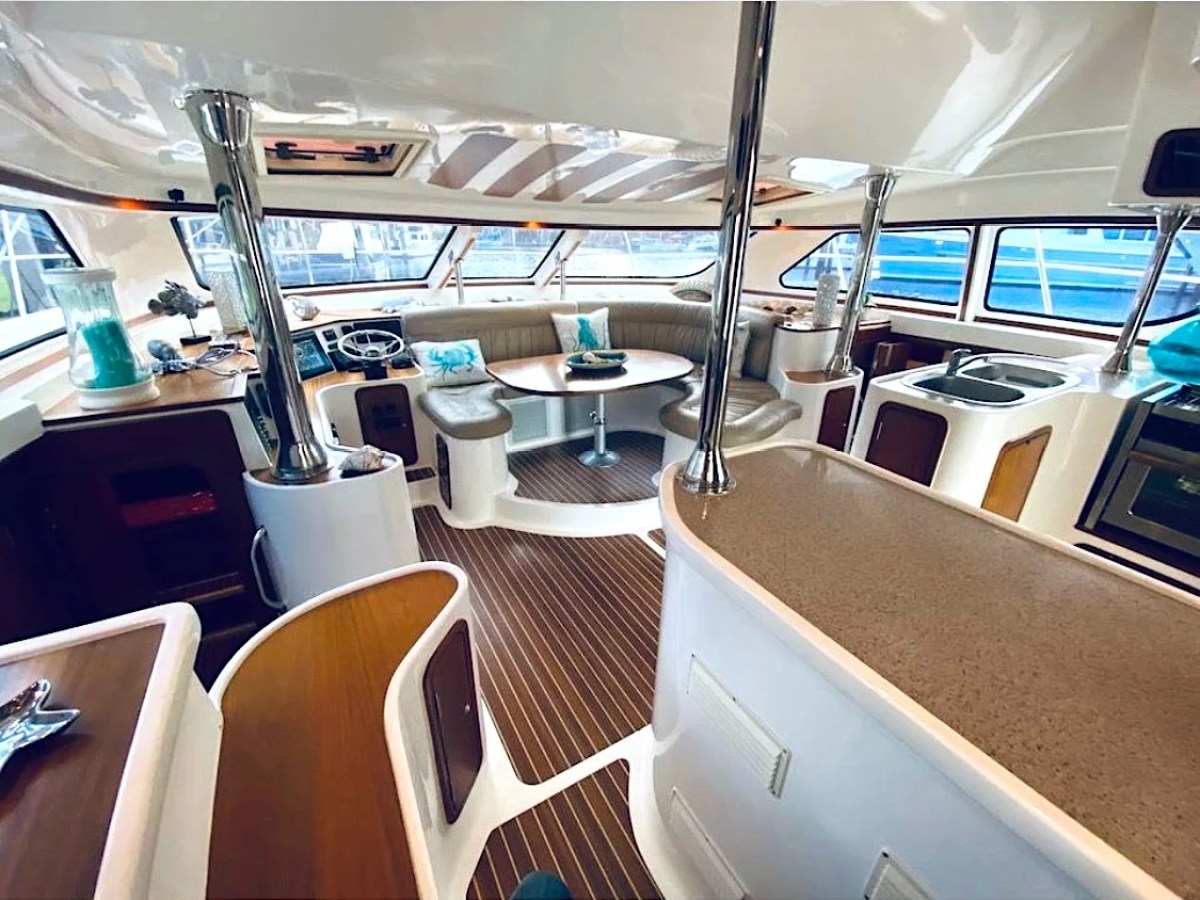 This 50 foot AfriCat Yacht Charter features a spacious salon with wraparound dining seating, interior helm station, and panoramic windows while docked in Fort Myers near Southwest Florida waterfront marinas.