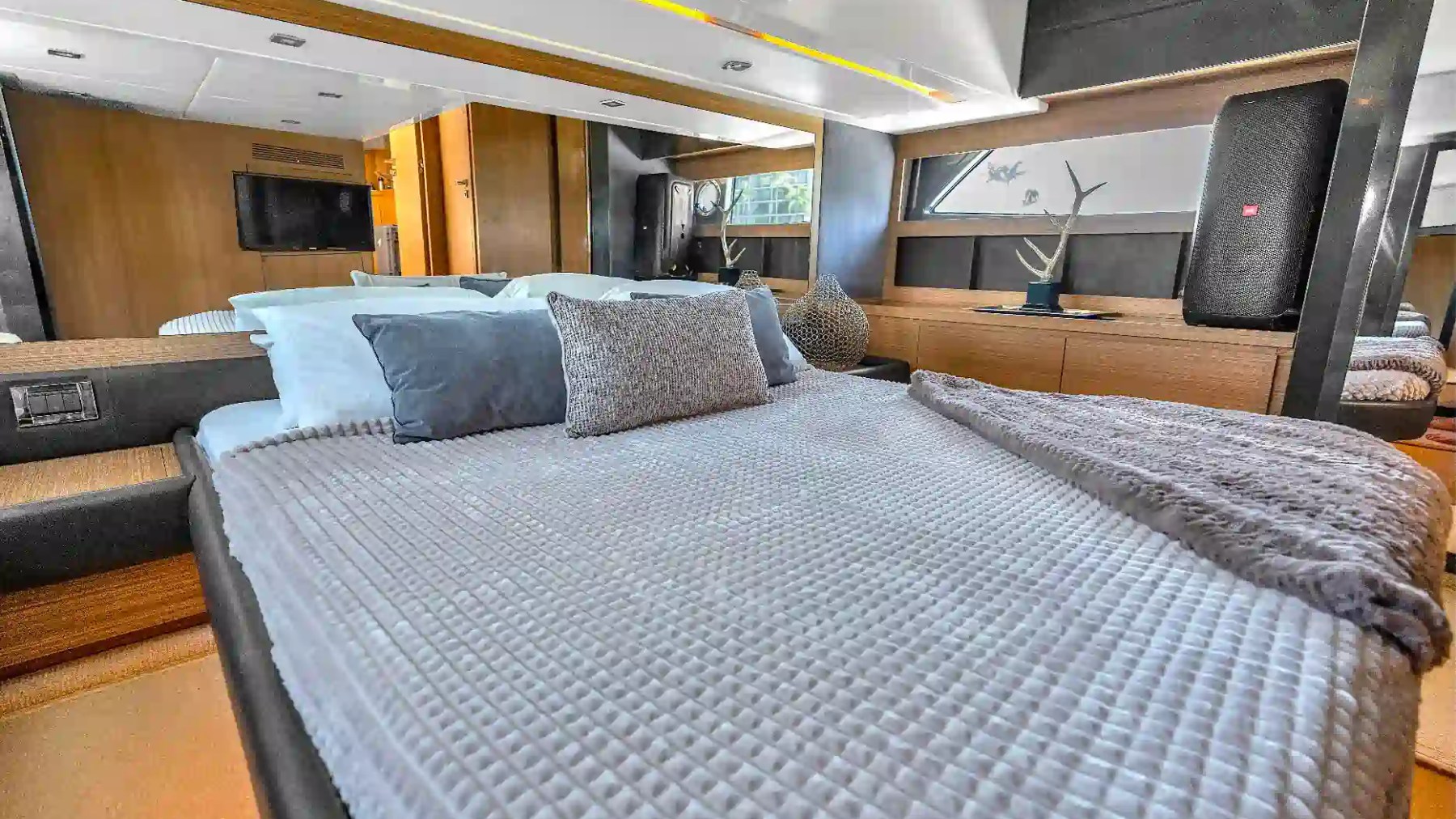 Luxury stateroom aboard a 50' Azimut Yacht Charter featuring a large berth, mirrored accents, wood cabinetry, ambient lighting, and contemporary interior styling in Miami.