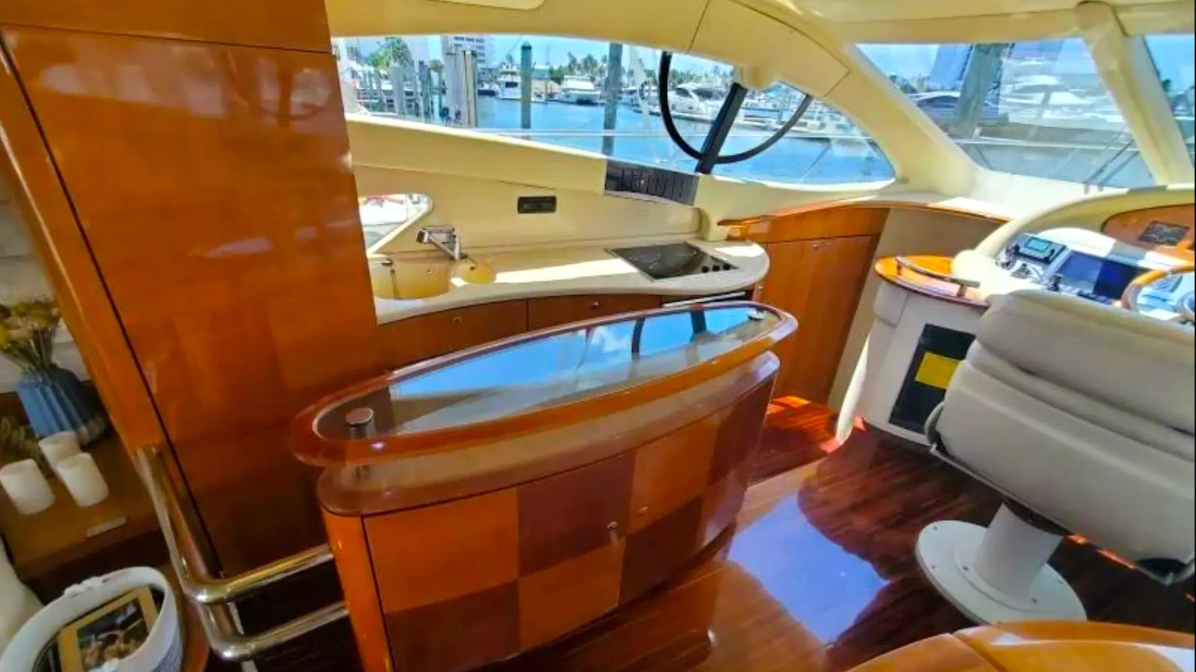 57' Azimut Yacht Charter galley and helm station featuring premium wood cabinetry, modern appliances, and panoramic marina views in Miami.