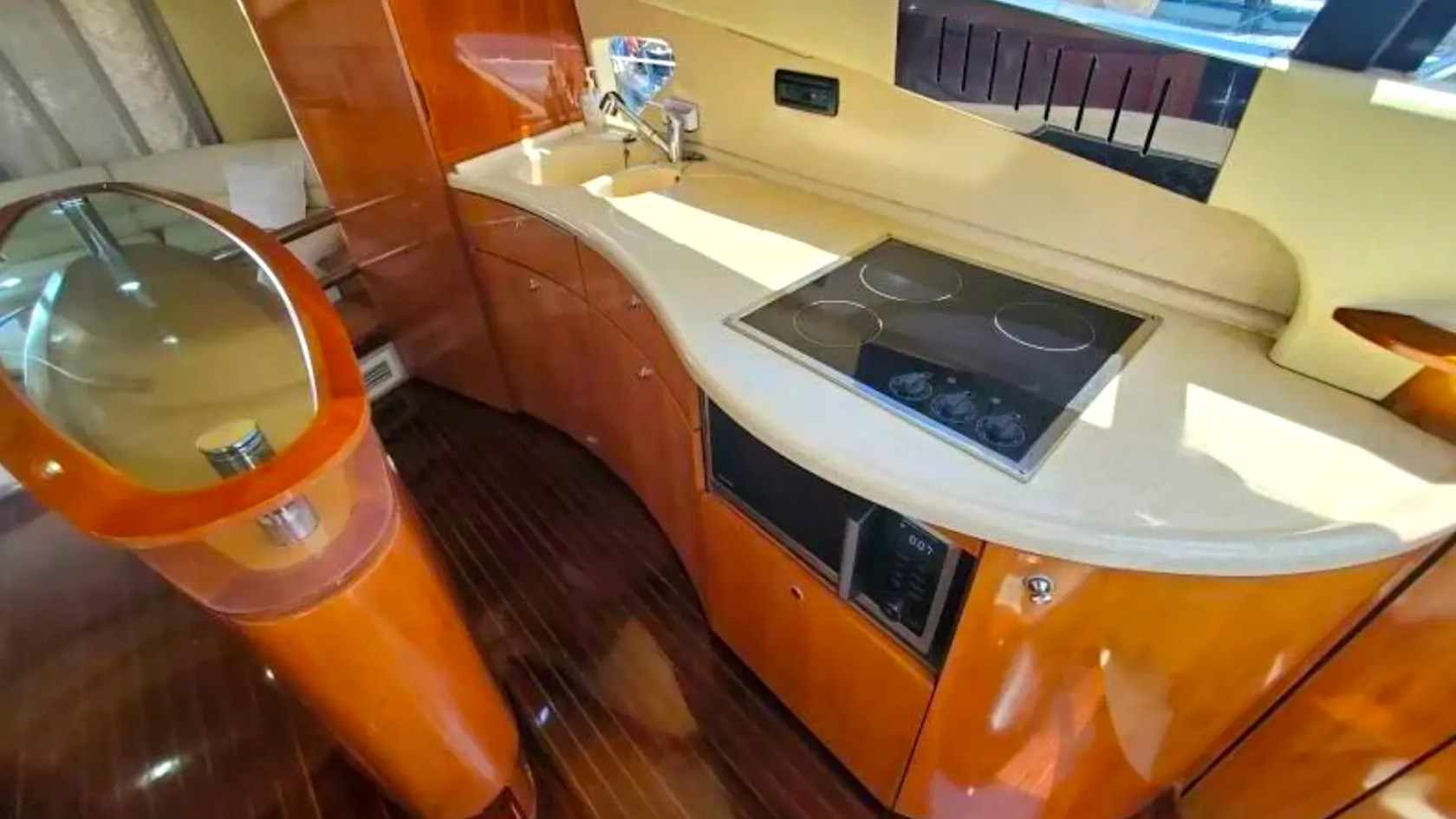 57' Azimut Yacht Charter galley featuring a modern kitchenette with cooktop, sink, microwave, and premium cabinetry for luxury dining in Miami.
