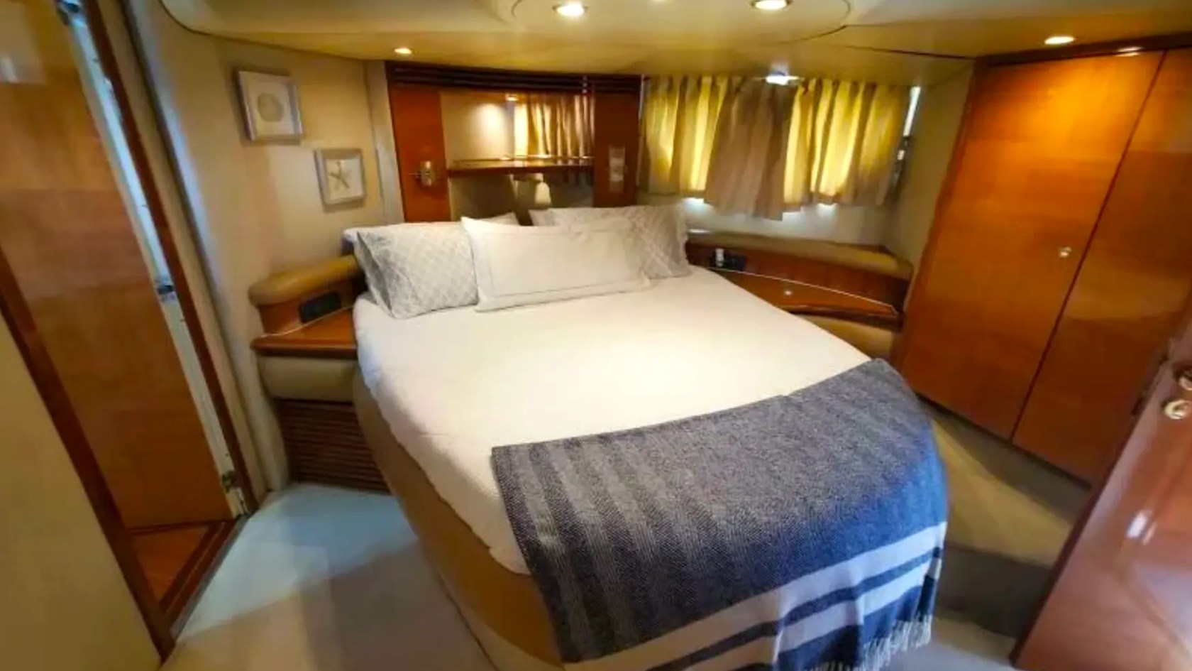 57' Azimut Yacht Charter master stateroom featuring a queen berth, elegant wood finishes, and private accommodations in Miami.