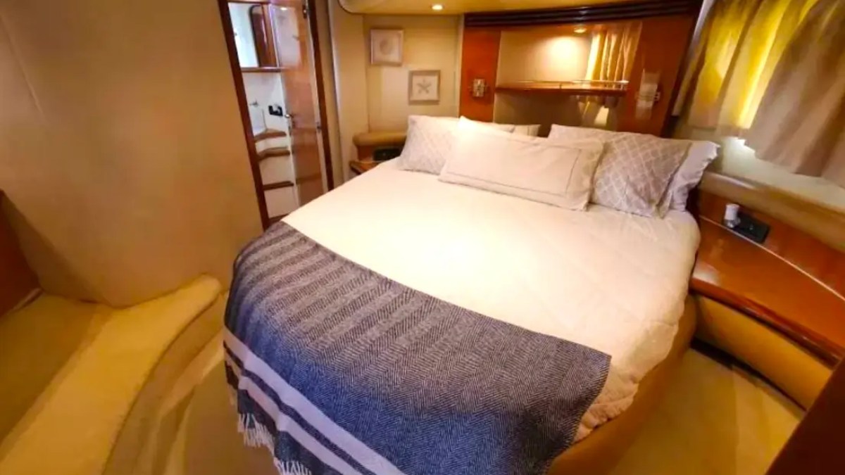 57' Azimut Yacht Charter master stateroom featuring a queen berth, elegant wood finishes, private ensuite access, and luxurious overnight accommodations in Miami.