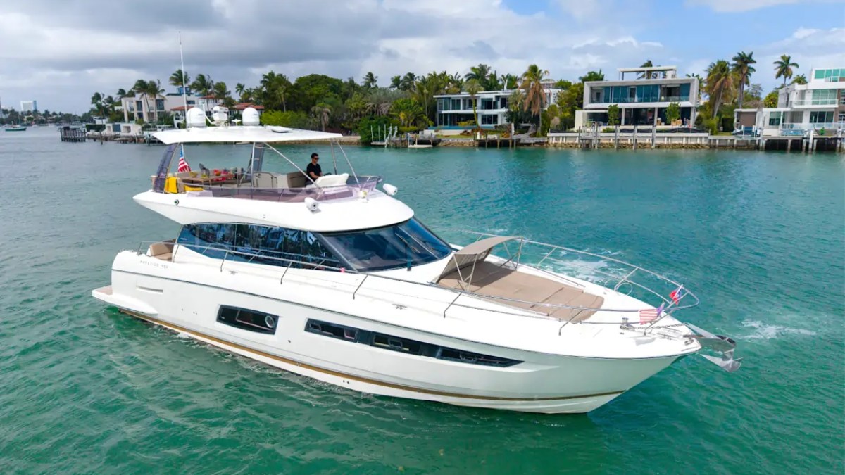 58' Prestige Yacht Charter cruising the turquoise waters of Biscayne Bay near Star Island with sleek flybridge styling and panoramic Miami waterfront views.