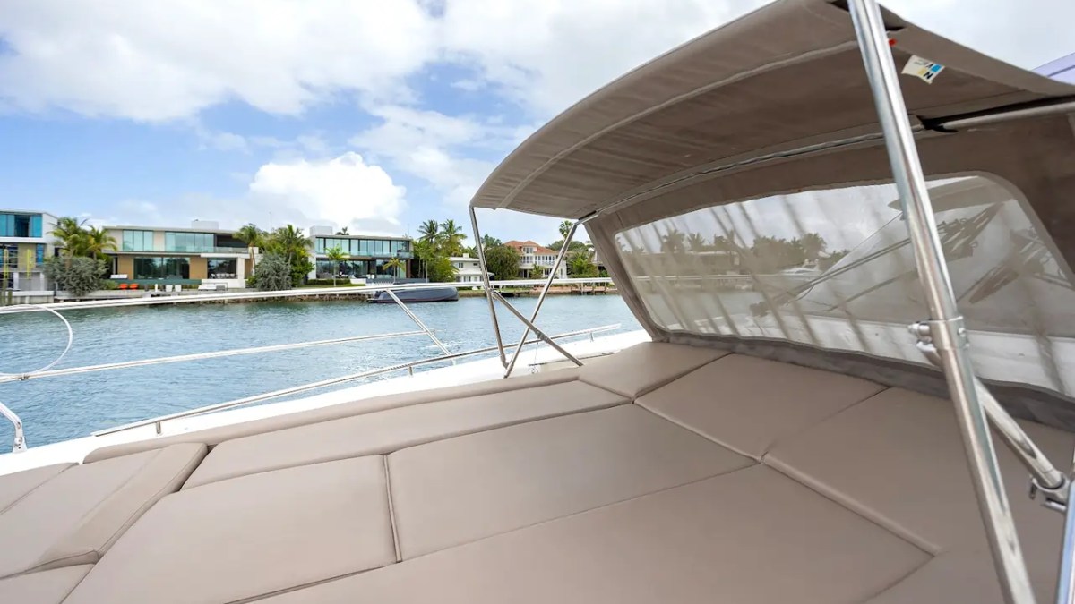 58' Prestige Yacht Charter oversized bow sun pad with retractable shade canopy cruising Miami's Millionaire's Row and Biscayne Bay waterfront.
