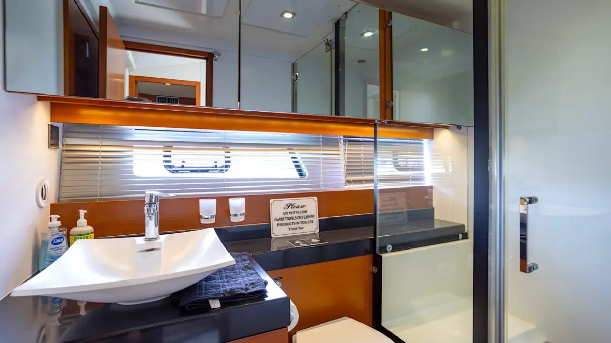 58' Prestige Yacht Charter ensuite bathroom featuring a modern vanity, glass shower, and premium finishes aboard a luxury Miami yacht.