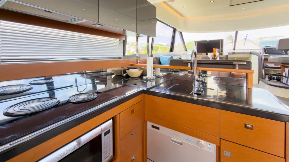 58' Prestige Yacht Charter gourmet galley featuring premium appliances, modern cabinetry, and an open-concept layout connected to the luxury skylounge while cruising Miami.