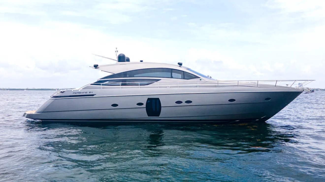 64' Pershing Yacht Charter cruising the turquoise waters of Biscayne Bay with sleek Italian performance yacht styling and the Miami skyline in the distance.