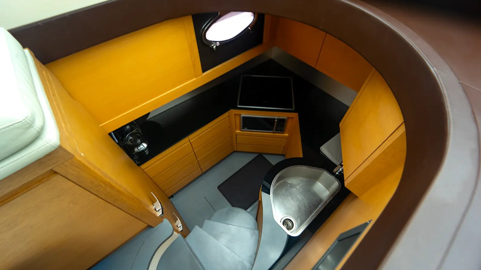 64' Pershing Yacht Charter lower galley featuring a modern kitchenette, premium appliances, and efficient Italian yacht design while cruising the waters of Miami, Florida.
