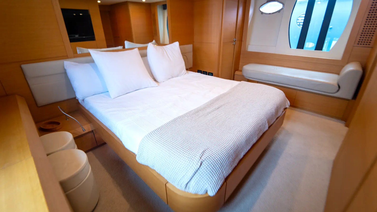 64' Pershing Yacht Charter master stateroom with king berth, elegant wood finishes, and luxurious overnight accommodations in Miami.