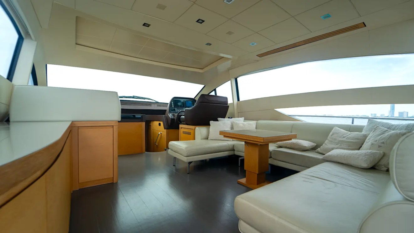 64' Pershing Yacht Charter spacious salon with panoramic windows, elegant lounge seating, and modern helm station cruising through the waters of Miami, Florida.