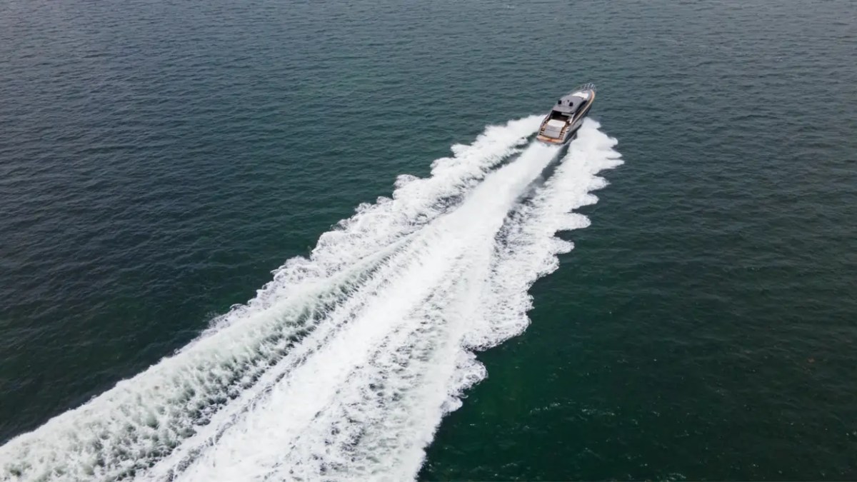 64' Pershing Yacht Charter captured from above accelerating across the Atlantic Ocean off Miami Beach, leaving a dramatic wake that showcases its legendary Italian performance.