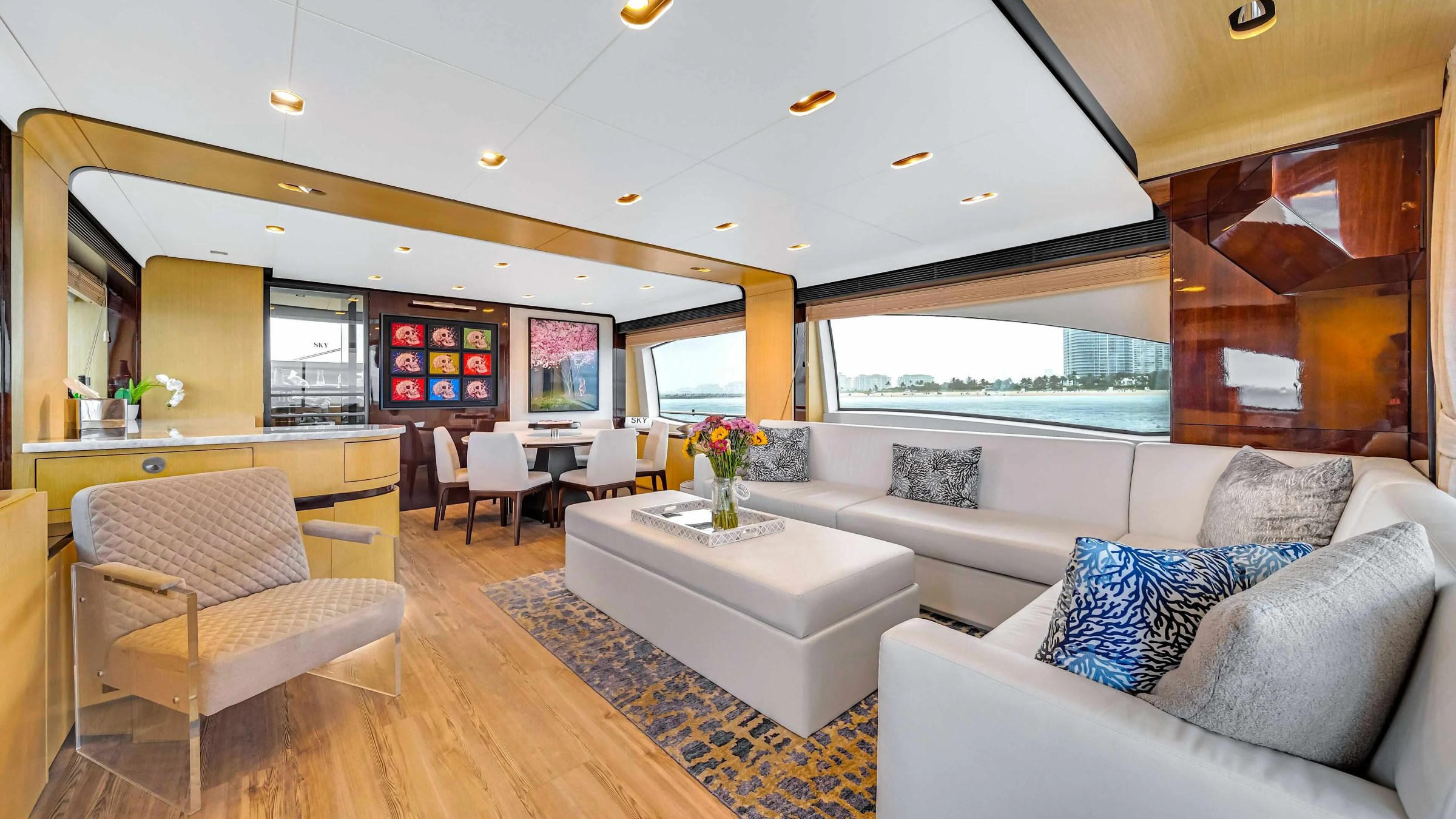84' Azimut Yacht Charter interior salon featuring contemporary lounge seating, formal dining area, panoramic windows, and refined finishes while cruising near Miami Beach.