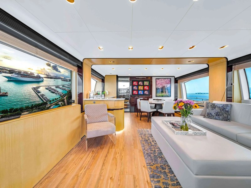 84' Azimut Yacht Charter interior salon featuring contemporary lounge seating, formal dining area, panoramic windows, and refined finishes while cruising near Miami Beach.