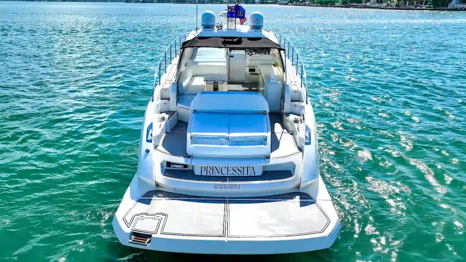 Stern view of a 50' Azimut Yacht Charter in Miami featuring a spacious swim platform, sun pad lounge, and open-air cockpit overlooking Biscayne Bay.
