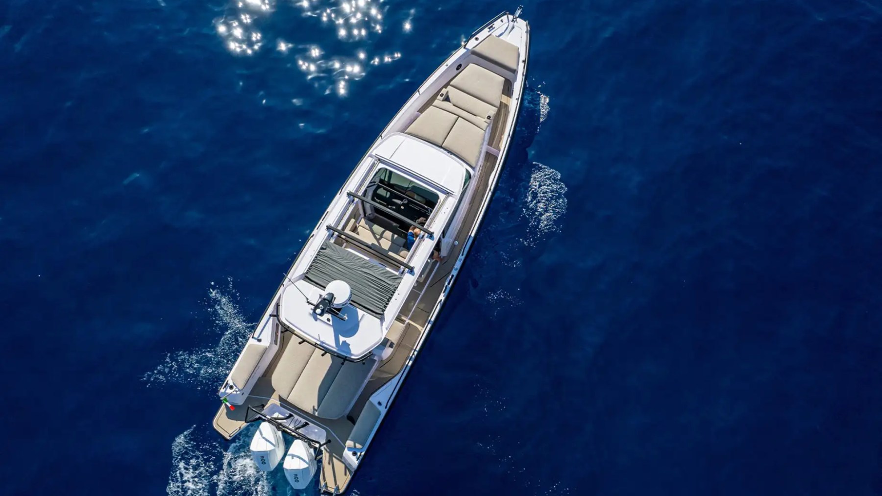 Aerial drone view of a 38' Axopar Boat Rental underway in deep blue Biscayne Bay waters near North Bay Village, showcasing spacious seating areas and twin outboard power from above
