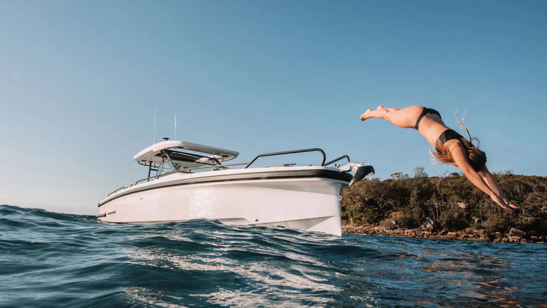 This 38 foot Axopar Boat Rental captures a guest diving into the water beside the vessel during a private boating adventure near North Bay Village and Biscayne Bay in Miami.
