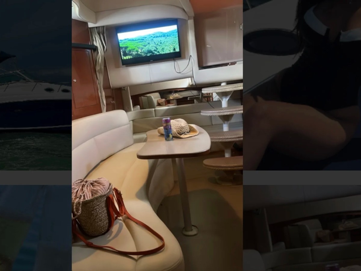 37' SeaRay Boat Rental salon with curved lounge seating and TV in Cape Coral.